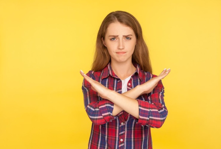 Ragazza esprime rifiuto incrociando le braccia